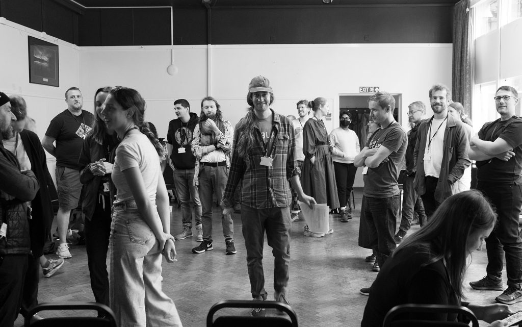 A small theatre full of people attending the Design Research Works Jamboree 2022. Dr. Joseph Lindley looking directly into the camera